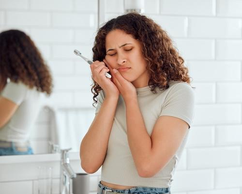 Woman holding her mouth in pain, indianapolis in