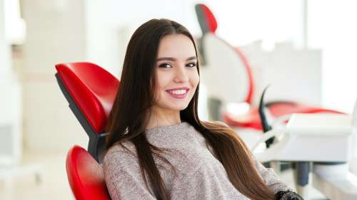Older brunette smiling in dental chair, indianapolis inc